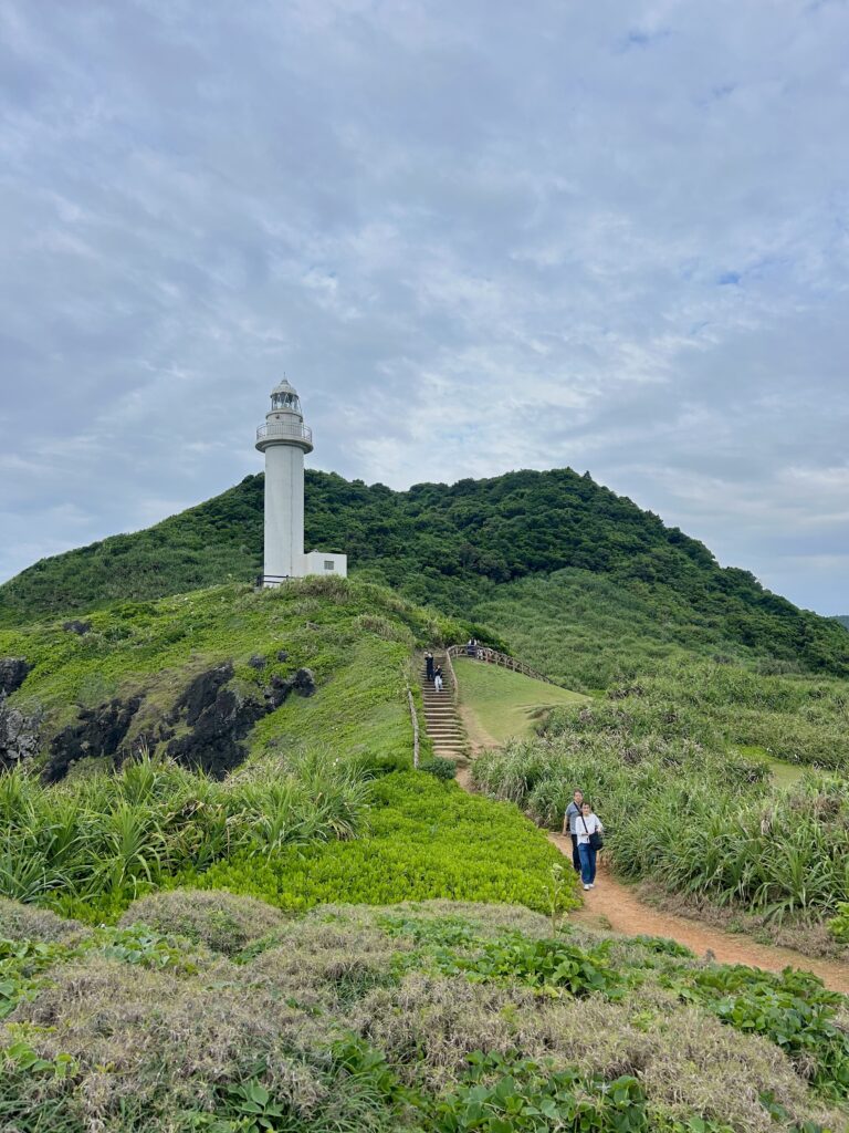 Hirakubozaki Lighthouse on a cloudy day with ocean cliffs in the background